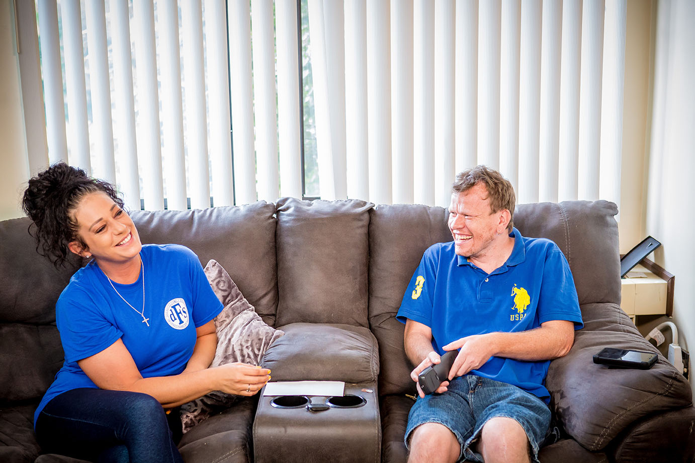 Man and woman smiling on couch talking