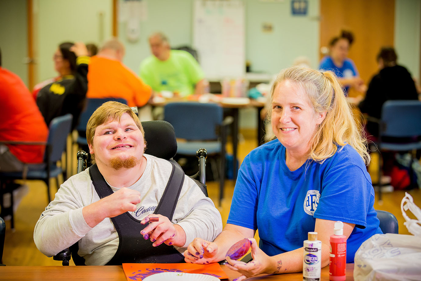 man and woman smiling while doing crafts