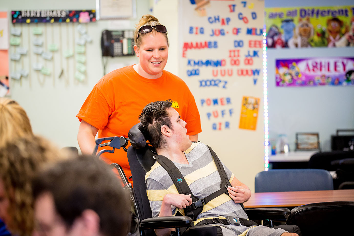 person in wheelchair with helper